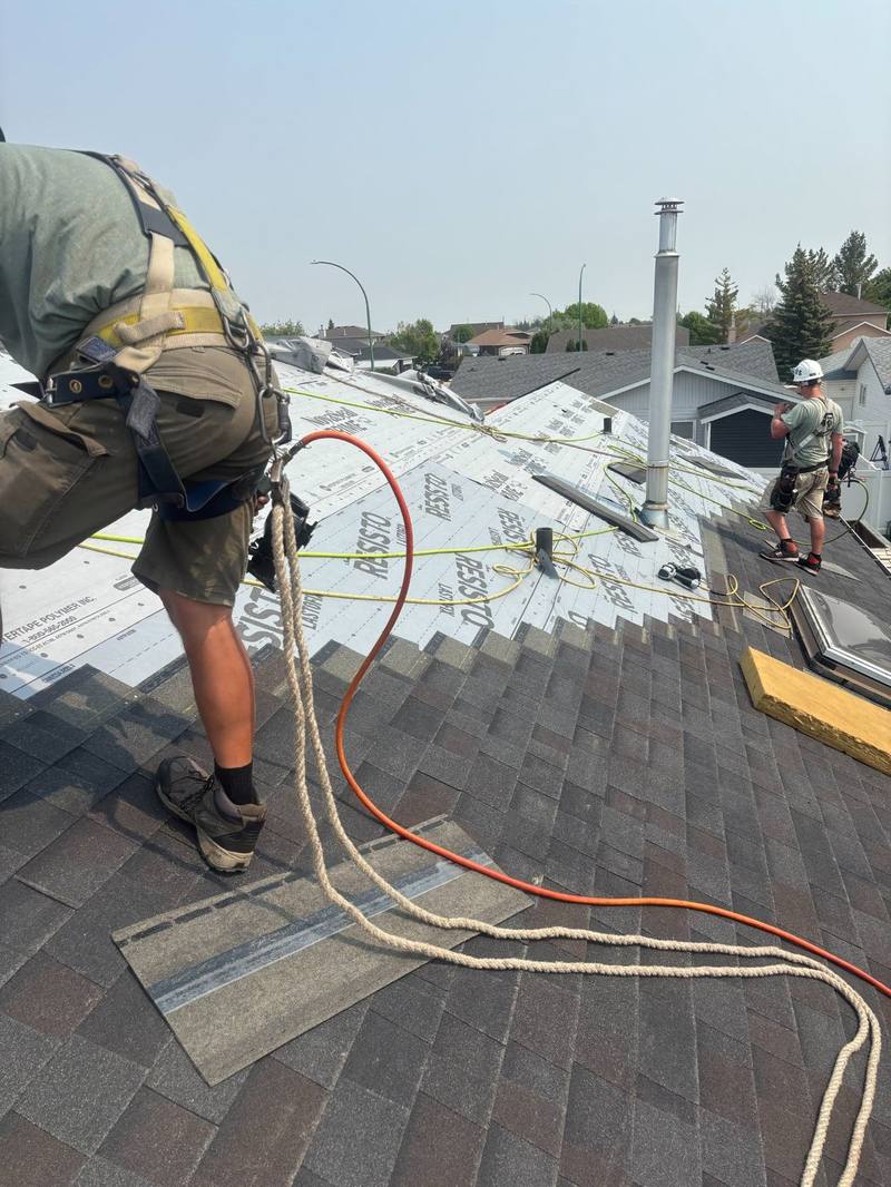 Molnar Roofing crew members Ryan and team working on a roof installation with safety harnesses in Yorkton Saskatchewan