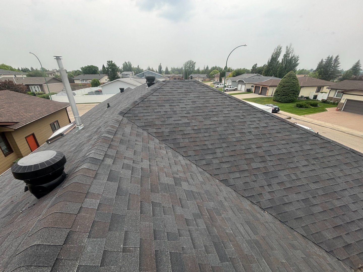 Completed dark architectural shingle roof replacement in Yorkton Saskatchewan neighbourhood by Molnar Roofing