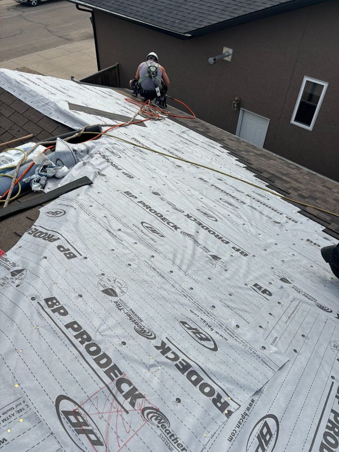Molnar Roofing crew member with safety harness inspecting roof with BP ProDeck underlayment in Yorkton Saskatchewan