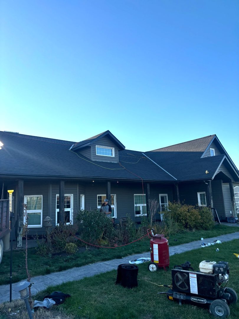 Dark exterior custom home with roofing work at dusk near Saltcoats Saskatchewan