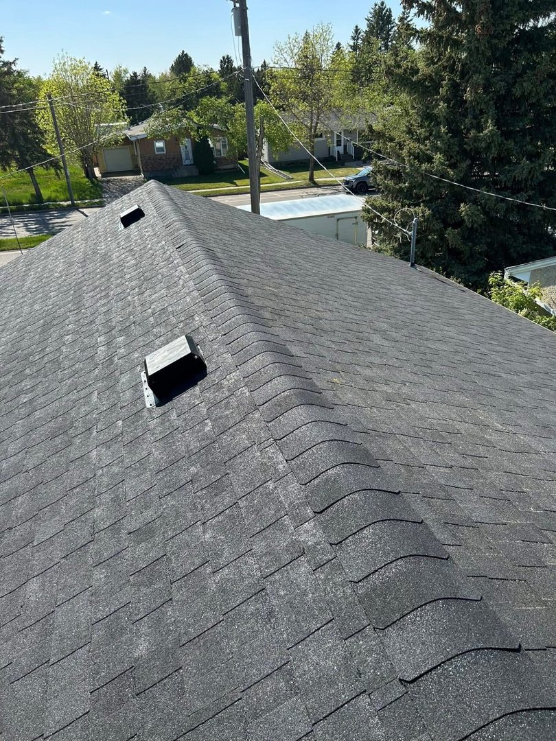 Completed dark shingle roof ridge near Sheho Saskatchewan